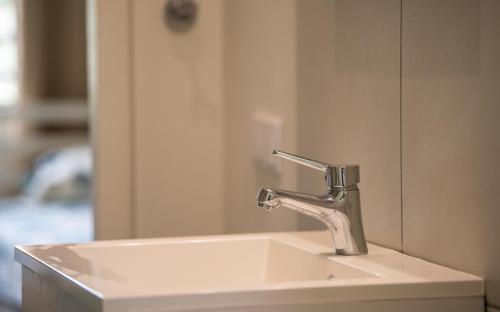 ein Waschbecken mit einem Wasserhahn und einem Spiegel in der Unterkunft Ultimate Caribbean Experience in Willemstad