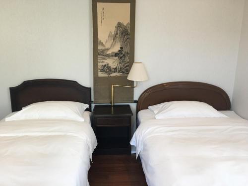 2 letti posti uno accanto all'altro in una stanza di 京都LanLan a Kyoto