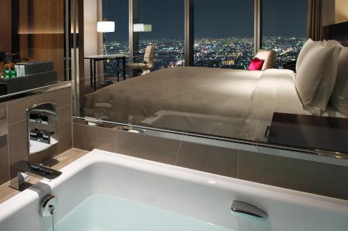 大阪市にある大阪マリオット都ホテルのベッド付きの客室で、バスタブが備わります。
