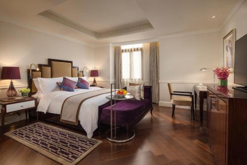 a bedroom with a large bed and a table and a desk at Metropolo Classiq, Shanghai, Bund Circle in Shanghai