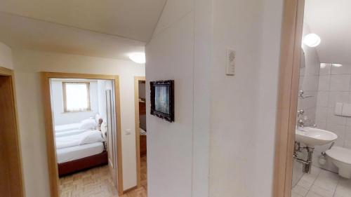 um banheiro com uma pia, um vaso sanitário e uma cama em Prüveda A0.1 em Silvaplana