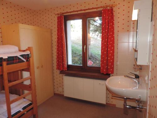 ein Bad mit einem Waschbecken, einem Fenster und einem Etagenbett in der Unterkunft Barlangia (455 Ho) in Valbella