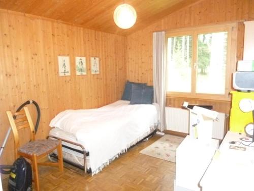 a bedroom with a bed in a room with wooden walls at Preschaint (720 Kü) in Valbella