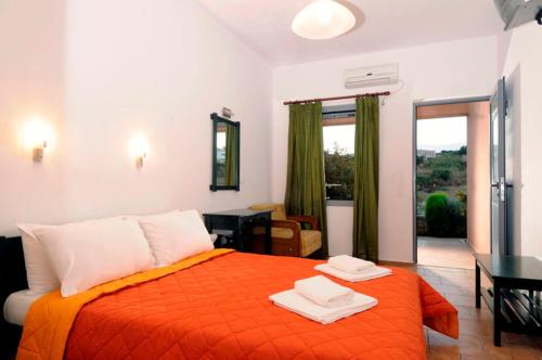 a bedroom with a bed with an orange blanket at Petradi in Livadi