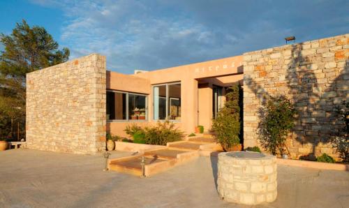 a large brick building with a stone wall at Petradi in Livadi