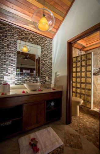 a bathroom with a sink and a mirror and a toilet at Marbucks Bed & Breakfast in San Pedro