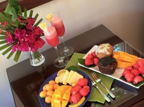a table with two plates of food and two wine glasses at Marbucks Bed & Breakfast in San Pedro