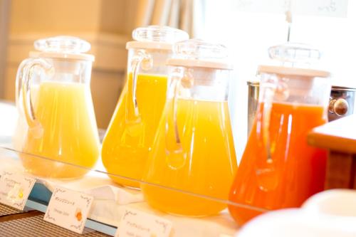 a group of four bottles of orange juice on a table at Matsumoto Marunouchi Hotel in Matsumoto