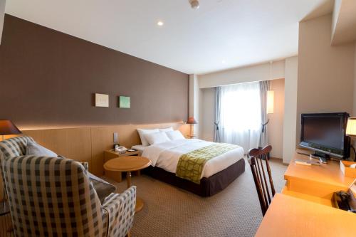 a hotel room with a bed and a television at Matsumoto Marunouchi Hotel in Matsumoto