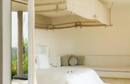 a bedroom with a white bed with a window at Sala Khaoyai in Wangkata