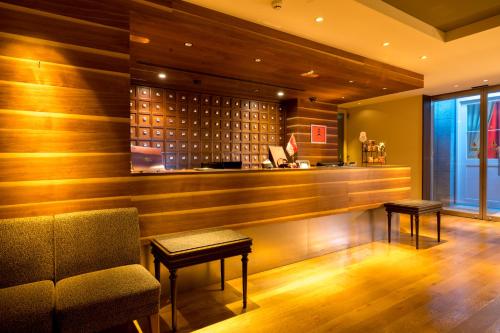 a bar with a couch and a chair in a room at Matsumoto Marunouchi Hotel in Matsumoto