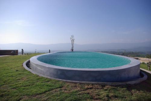 a large pool of water in a grass field at Sala Khaoyai in Wangkata