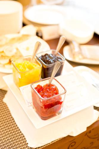 a table with three containers of jam and other condiments at Matsumoto Marunouchi Hotel in Matsumoto