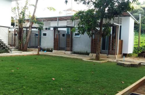 a house with a green yard in front of it at Koh Mak Cococape Resort in Ko Mak