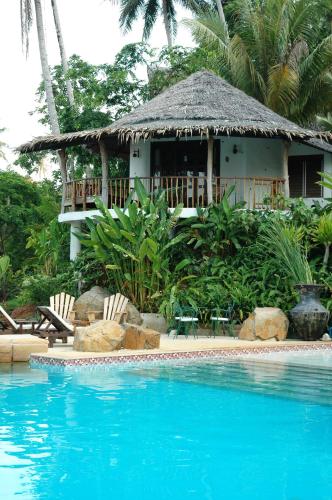 a resort with a swimming pool in front of a house at Koh Mak Cococape Resort in Ko Mak