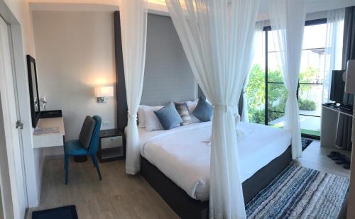 1 dormitorio con 1 cama con cortinas y ventana en La Playa Beach Front Pool Villa Cha-am,Huahin, en Cha Am