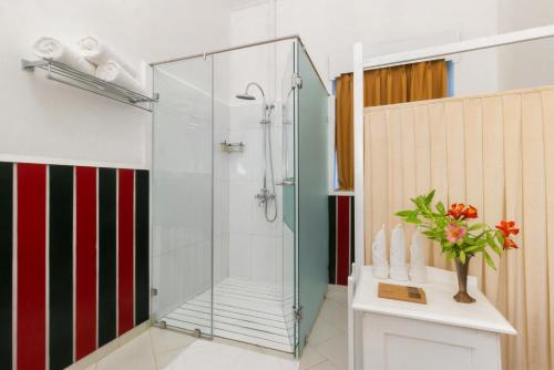 a shower with a glass door in a bathroom at Scottish Planter Bungalow- Thema Collection in Nuwara Eliya