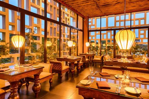 a restaurant with tables and chairs and large windows at Jetwing Jaffna in Jaffna