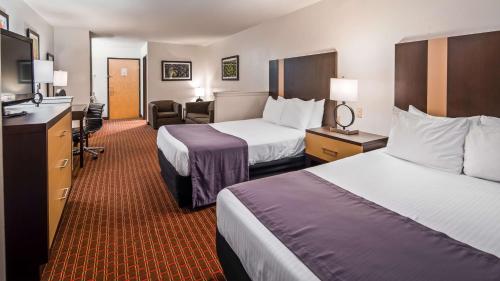 a hotel room with two beds and a desk at Best Western Inn and Suites Copperas Cove in Copperas Cove