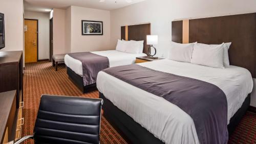 a hotel room with two beds and a chair at Best Western Inn & Suites in Copperas Cove