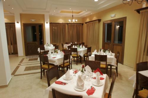a dining room with white tables and chairs at Villa Belles in Akritochori