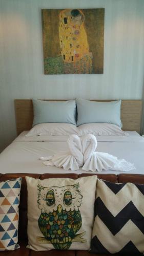 a bed with pillows and a painting of a skull at Grand Blue Condominium by Mary in Mae Pim