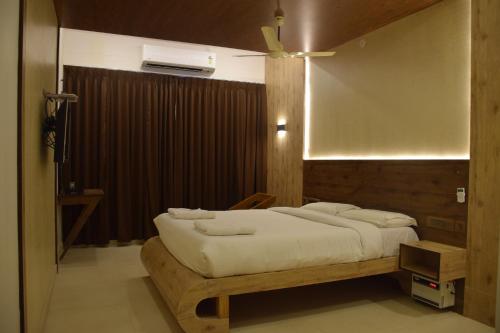a bedroom with a large bed with a wooden frame at Hotel Christo's in Velānganni