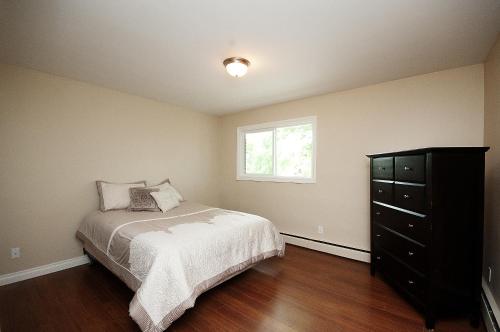 1 dormitorio con cama, ventana y vestidor en McKinnon Pointe #307, en Edmonton