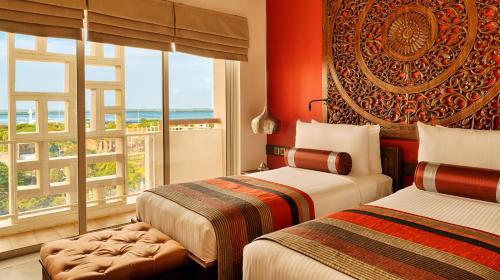 Una habitación de hotel con dos camas y una ventana. en Jetwing Jaffna, en Jaffna