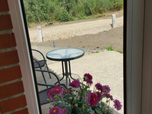 a table and chairs on a porch with flowers at Kyndestoft Bed & Breakfast in Holstebro
