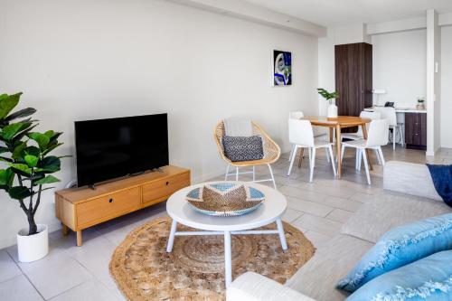 a living room with a tv and a table at First Light Mooloolaba, an Ascend Collection Hotel in Mooloolaba