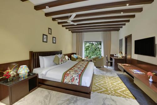 a bedroom with a large bed and a tv at The Kumbha Residency by Trulyy - A Luxury Resort and Spa in Kumbhalgarh