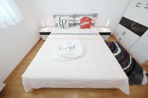 a bedroom with two beds with white sheets and pillows at Apartment Lana in Pašman
