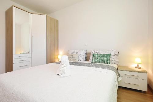 a bedroom with a white bed and a mirror at Apartment Lana in Pašman