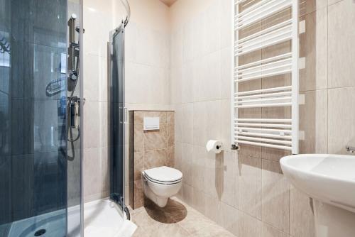 een badkamer met een toilet, een wastafel en een douche bij Polin House in Oświęcim