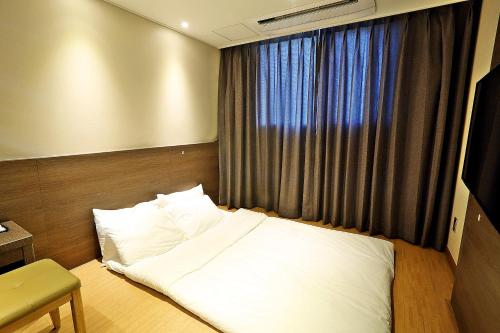 Кровать или кровати в номере Grandmillions Hotel Seogwipo