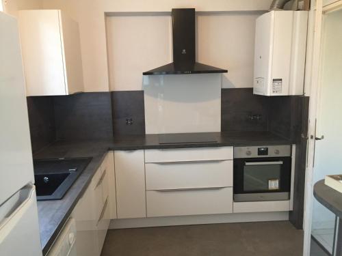 a kitchen with white cabinets and a stove at SETE - 6 Quai Louis Pasteur in Sète
