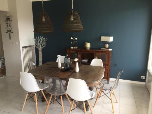 a dining room with a wooden table and white chairs at SETE - 6 Quai Louis Pasteur in Sète