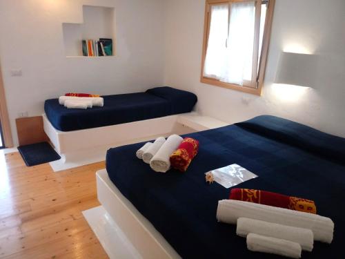 a room with two beds with towels on them at casa Namaste in Porto Columbu - Perdʼe Sali