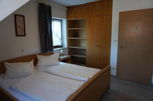 1 dormitorio con 1 cama con sábanas blancas y ventana en Zenntaler Hof, en Neuhof an der Zenn