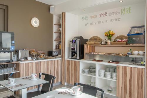 a dining room with a table and a coffee shop at Cit'Hotel Imperial in Sète