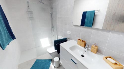 a white bathroom with a toilet and a sink at Villa Casa Juma in Playa Blanca