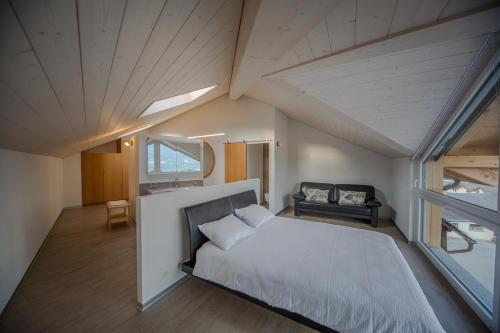 SavièseにあるFleur de Lysのベッドルーム(大きな白いベッド1台、窓付)