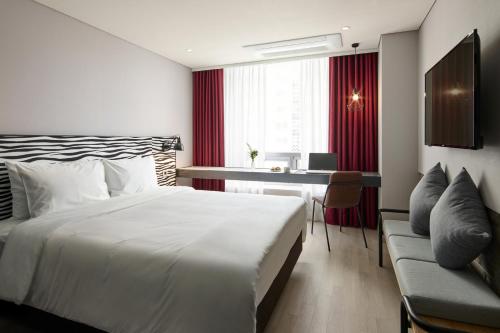 a hotel room with a bed and a desk at Hotel NewV in Seoul