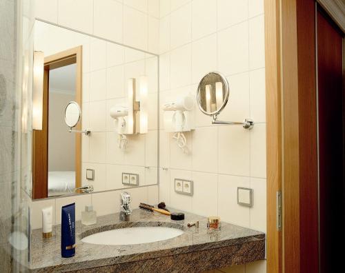 a bathroom with a sink and a mirror at Hotel Rauch in Ettringen