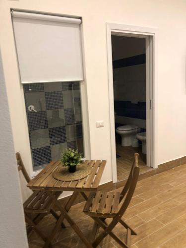 a table and chairs in a room with a toilet at Casa Vacanze Riva Destra in Ischia