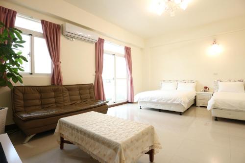 a living room with two beds and a couch at Nice Comfortable Homestay in Taitung City