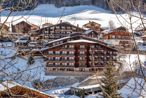 a large building in the snow with snow at Hotel le Petit Dru in Morzine