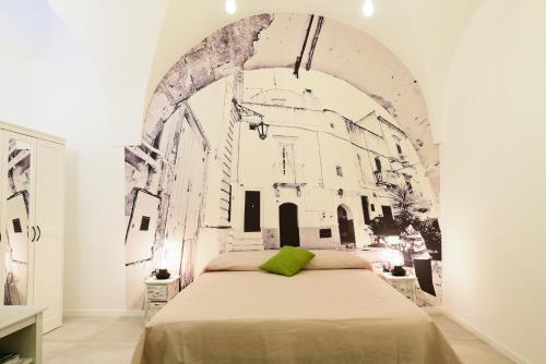 Un dormitorio con una cama con un cuadro en la pared. en da Nonna Lata, en Martina Franca