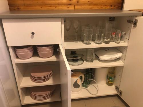 a cupboard with plates and dishes in it at Aqua Faház in Mesteri